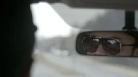 Driver Reflection in Rearview Mirror with Sunglasses Stock Footage 343936385
