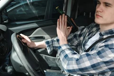 Driver refusing from alcohol while woman suggesting him beer in car, closeu.. Stock Photos