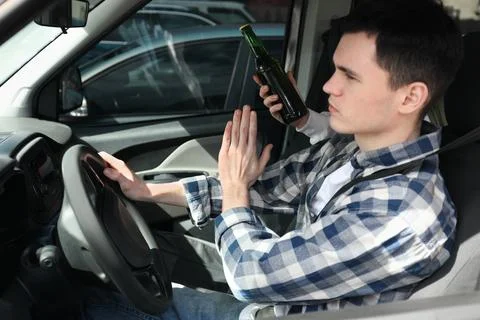 Driver refusing from alcohol while woman suggesting him beer in car, closeu.. Stock Photos