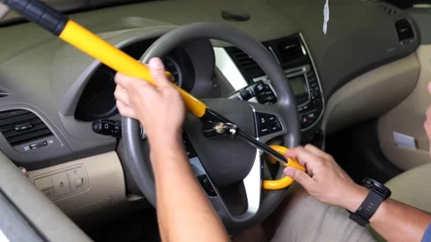 Driver removes steering wheel lock from steering wheel Stock Footage 250199683