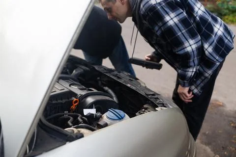 A driver replacing the car battery. Car battery repair and inspection. 스톡 사진
