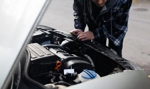 A driver replacing the car battery. Car battery repair and inspection. 스톡 사진