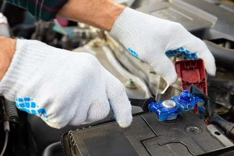 The driver is replacing the car battery. Stock Photos