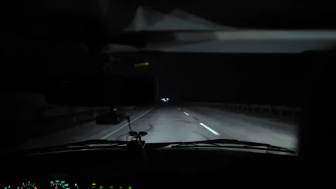 Driver rides at night on a lighted road. Inside view. Headlights light the way. Stock Footage 123178750
