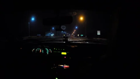Driver rides at night on a lighted road. Inside view. Headlights light the way. Stock Footage 123178771