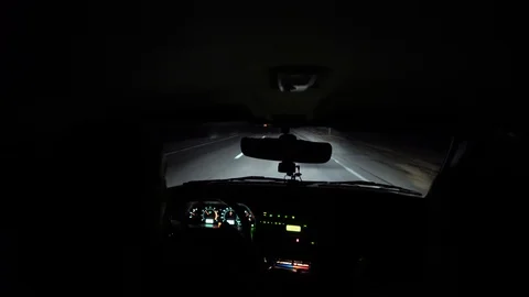 Driver rides at night on a lighted road. Inside view. Headlights light the way. Stock Footage 123178793