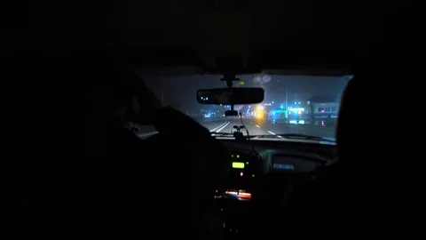 Driver rides at night on a lighted road. Inside view. Headlights light the way. Stock Footage 123178808
