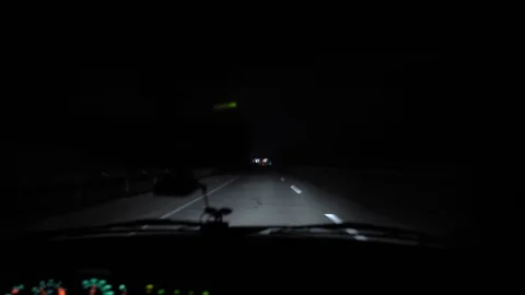 Driver rides at night on a lighted road. Inside view. Headlights light the way. Stock Footage 123399937