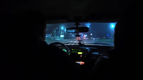 Driver rides at night on a lighted road. Inside view. Headlights light the way. Stock Footage 123399946