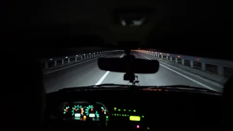 Driver rides at night on a lighted road. Inside view. Headlights light the way. Stock Footage 123399963