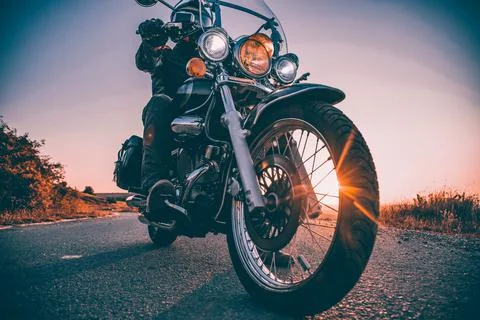 Driver riding motorcycle on an empty road Stock Photos