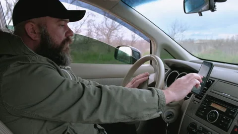 The driver searches for a route using the phone's navigator. Outside the city Stock Footage 154055217