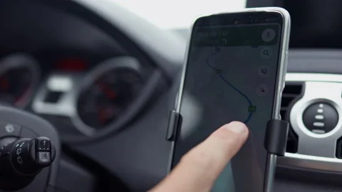 The driver sets up the JPS navigator on the smartphone. The driver is drivin Stock Footage 205485257