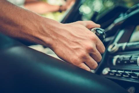 Driver Shifts Gears While Inside a Classic Car During a Sunny Afternoon Stock Photos
