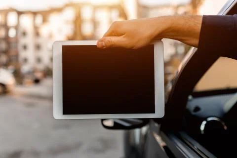 A driver shows a tablet pc screen close-up into the camera. Empty space for your Stock Photos
