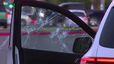DRIVER SIDE WINDOW SHOT UP WITH BULLET HOLES IN GANG SHOOTING Stock Footage 346603035