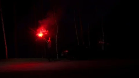 Driver with a signal fire in hands waving his hand to rescuers Stock Footage 89732600