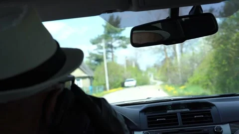 Driver sits in car view from back seat and village outside Stock Footage 131417686