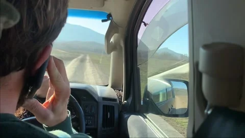 Driver smartphone cell phone talking while ride country dirt road Stock Footage 146504797