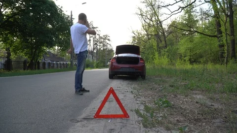 Driver standing beside broken down vehicle making emergency call. Stock Footage 92044743