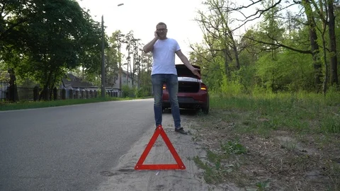 Driver standing beside broken down vehicle making emergency call. Stock Footage 92044813