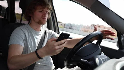 Driver stares at smartphone while moving and loses focus on the road Stock Footage 343719804