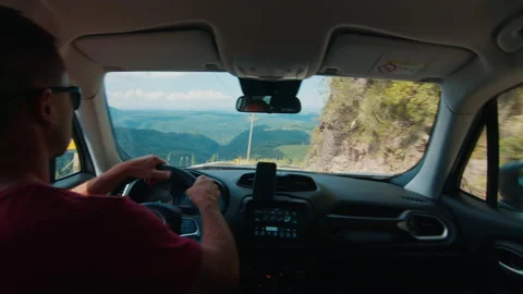 Driver steers the car on an extremely bumpy and narrow road in highlands Stock Footage 233289218