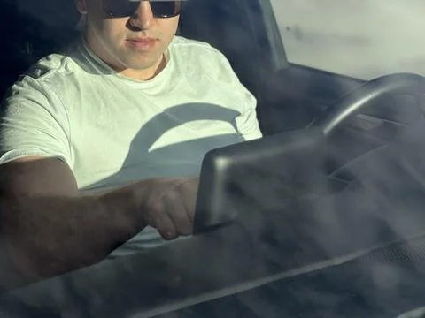 Driver touching central dashboard multimedia screen in car Stock-Fotos