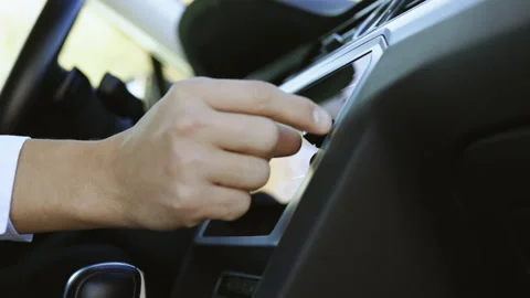 The driver turned to the radio. Adjusting volume of speaker with fingers to Stock Footage 194752556