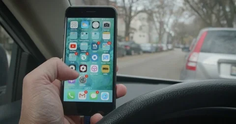 Driver turning on Uber App going through the interface on the iPhone while in Stock Footage 82850652