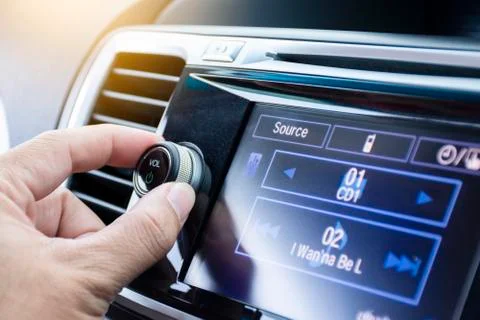 Driver turning volume button of car radio Stock Photos