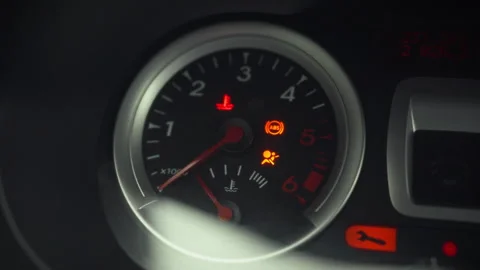 The driver turns ignition key initiating cars startup sequence as warning li Stock Footage 331363609