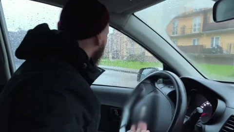 The driver turns by twisting the steering wheel to the right in a residential ar Stock Footage 253817914