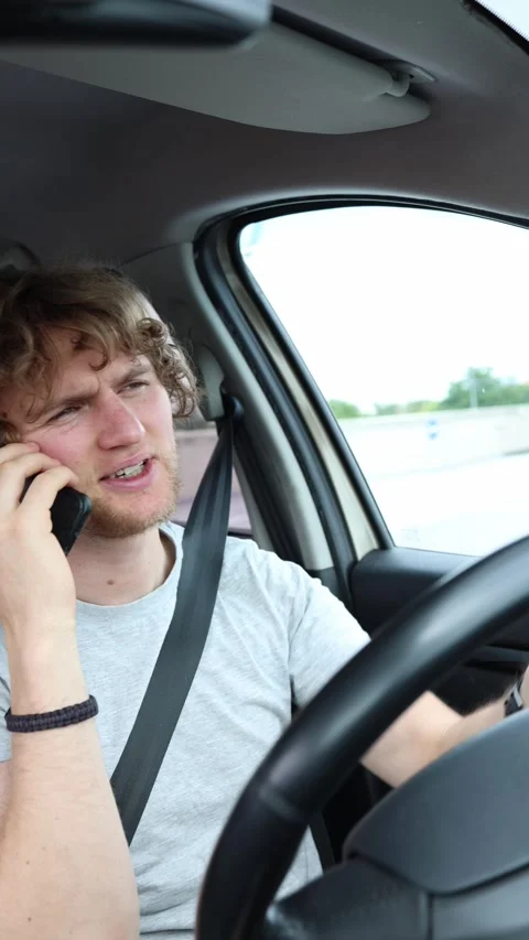 Driver uses a handheld phone behind the wheel in a dangerous traffic violation Stock Footage 342921048