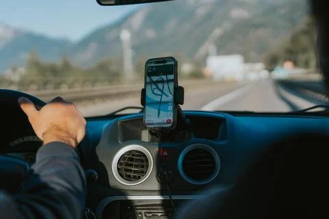 Driver using gps navigation on smartphone while driving on highway Stock Photos