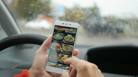Driver using his smartphone to order pizza online. Man Orders Pizza Using Onl Видео 96094240