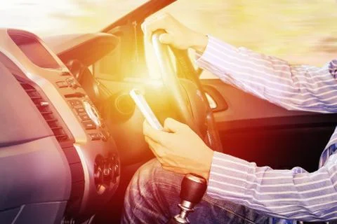 Driver using mobile phone :hand using phone sending a text or find locations and Stock Photos