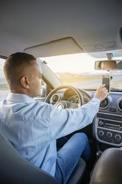 Driver using a mobile phone inside his car. 스톡 사진