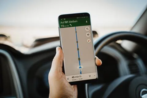 Driver using mobile phone navigation while driving car Stock Photos