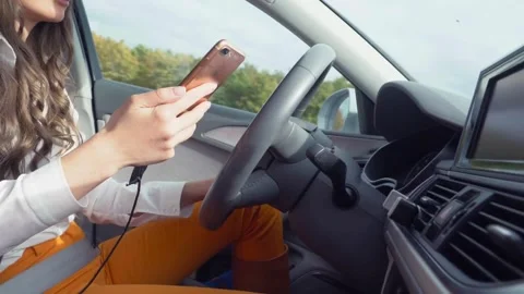 Driver using phone while sitting behind steering wheel. Technology and Stock-Footage 336267039