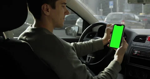 Driver using a smartphone inside the car. Chromakey iPhone 11 Pro Max green scre Stock Footage 141200346