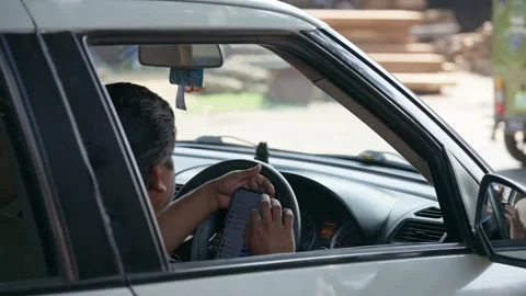 Driver using smartphone while sitting inside car on roadside in city Stock Footage 333227930