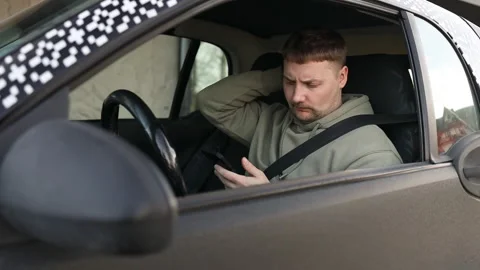 Driver using smartphone while wearing seatbelt in parked car Stock Footage 340141712