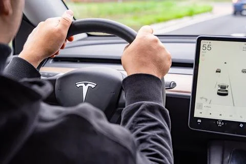 Driver Using Tesla Autopilot Display While Driving Stock Photos