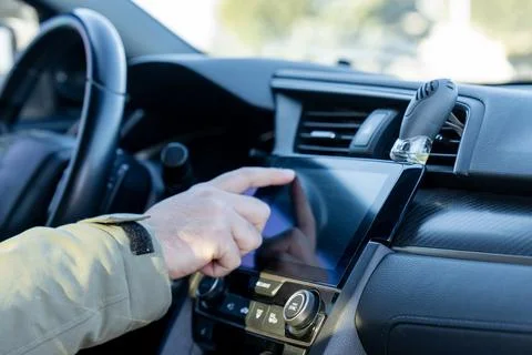 Driver using touchscreen infotainment system inside a modern car Foto stock
