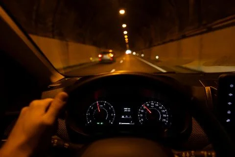 Driver view to the car speedometer. Blurred tunnel road with traffic ahead. Stock Photos