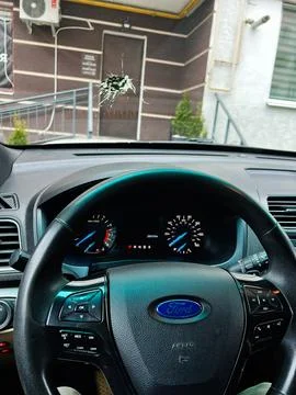 Driver view of a Ford steering wheel and cracked bird droppings windshield .. Stock Photos