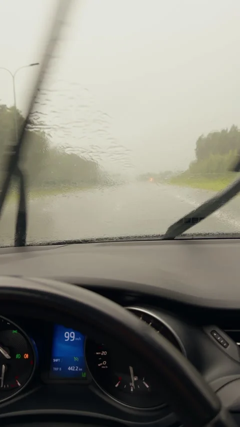 Driver view inside car on rainy highway with windshield wipers, blurred road Stockbeeldmateriaal 345530397