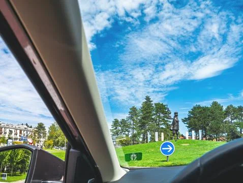 Driver view of roundabout with statue on green hill in Le Touque 写真素材