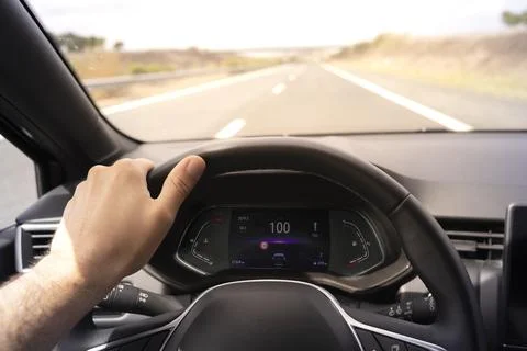 Driver view to the speedometer at 100 kmh, with hand on the steering wheel. Stock Photos